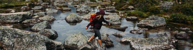 Person walking on rocky riverbed, Moraine lake, Banff National Park, Alberta