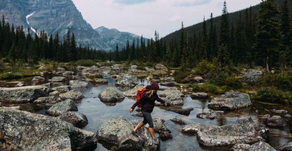 Person walking on rocky riverbed, Moraine lake, Banff National Park, Alberta