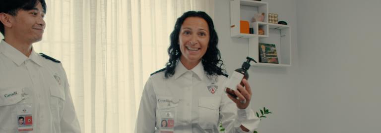 A CATSA screening officer holding up a bottle of soap.